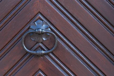 Close-up of a door knocker on a chevron-patterned door Stock Photos