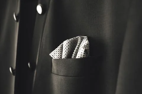 Close up of dot pattern handkerchief in breast pocket of man's black suit. Men's Stock Photos