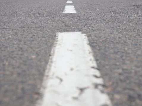 Close-up dotted line on an empty street, a line extending into the distance.s Stock Photos