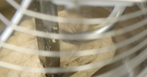 Close-up of dough folding around central mixer blade inside commercial bakery Stock Footage 344597547