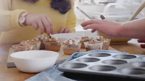 Close Up Of Downs Syndrome Couple Decorating Homemade Cupcakes With Marshmallows Stock Footage 114304064