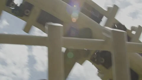 Close up of the downside of a rollercoaster rushing by over tracks in slow Video stock 337745173