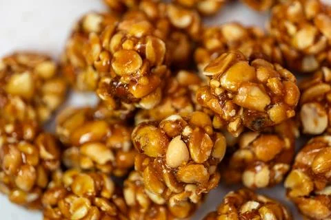 A close-up of a dozen chikki peanut balls on a white background Stock Photos