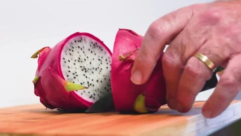 Close up of a dragon fruit (Pitaya) as a knife cuts it in half Stock Footage 320673590