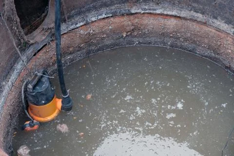 Close-up drain pump in a cesspool filled with contaminated water with feces Foto stock