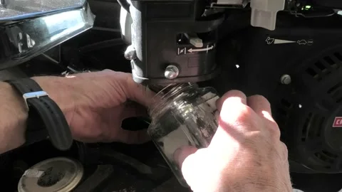 A Close Up of Draining Fuel From a Small Engine Carburetor Stock Footage 192649424
