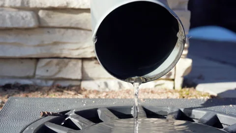 Close-up of drainpipe. Water flowing from gutter or drain into drainage system. Video stock 239946234