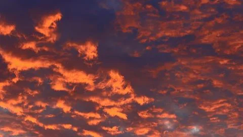 Close-up of a dramatic twilight sky filled with intensely glowing fiery red and Stock Photos
