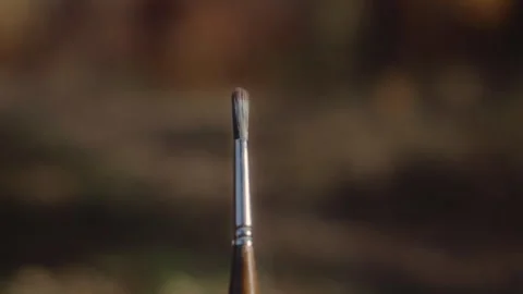 Close-up drawing brush standing on easel against the background of autumn forest Видео 337118242