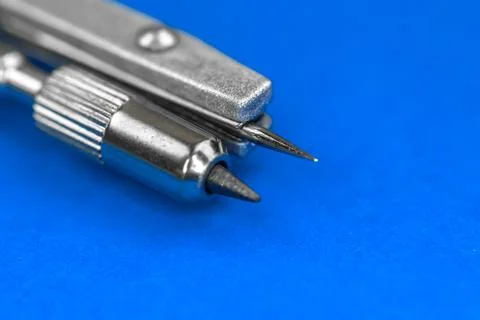 Close-up of drawing compass on blue bright background Stock Photos