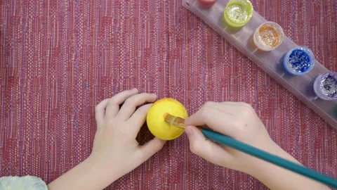 Close-up, drawing an Easter pattern on a yellow egg Stock Footage 150148770