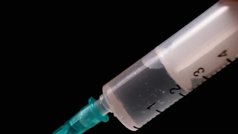 Close-up, drawing of liquid medicine, solution, vaccine into a syringe on dark. Stock Footage 164120593