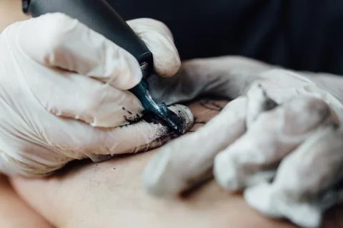 Close up of drawing process on skin of black-and-white tattoo and shading of Stock Photos