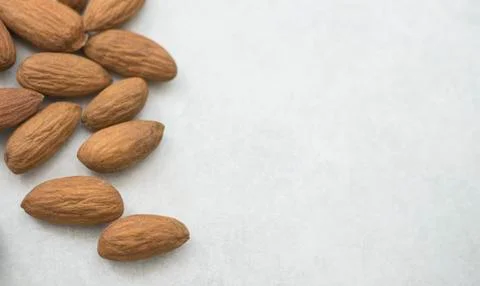 Close up dried almonds on left side white grey background Stock Photos