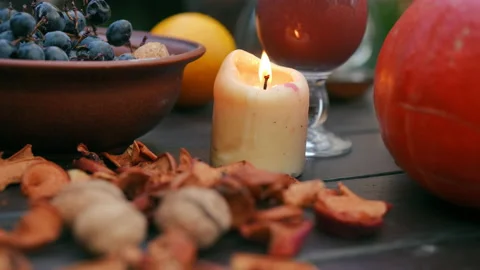 Close-up dried fruits falling on table with burning candle outdoors. Delicious Stock Footage 237517475