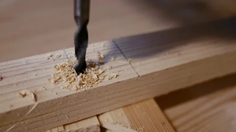 Close-up of a drill bit being used to drill into a wooden plank.  Stock Footage 259947375