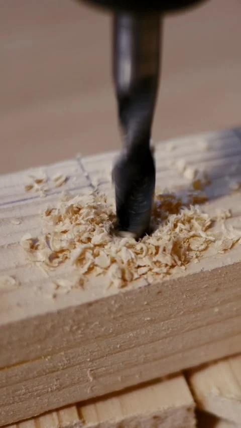 Close-up of a drill bit being used to drill into a wooden plank. Stock Footage 321353393
