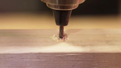 Close-up of a drill bit boring into a wooden bar and producing wood chips Stock Footage 335213206