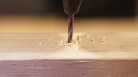 Close-up of a drill bit entering a pre-drilled hole in a wooden bar Stock Footage 335214673