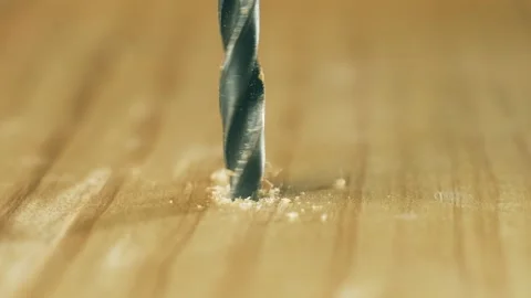 Close-up drill bit piercing wooden surface during construction. Macro view metal Stock Footage 315459554