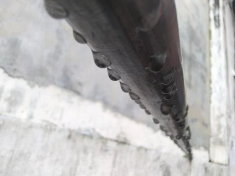 Close-up of a drill bit with sharp teeth digging into a surface. Stock Photos