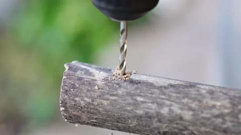 Close-up. the drill makes a hole in the poles for the construction of the hedge. Vídeo Stock 229576986