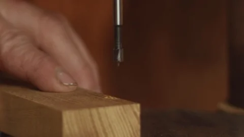 Close up of drill press making holes in hard hedge wood in glorious 4K - Video stock 107670493
