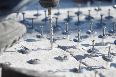 Close-Up of Drilling Process on a Concrete Base with Fasteners Stock Photos