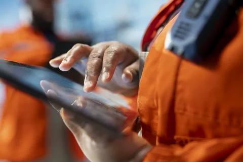 Close up of drilling rig specialist using tablet to evaluate carbon footprint Foto stock