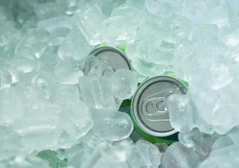 Close up on drinking cans inside ice blocks in the cooler Stock Photos