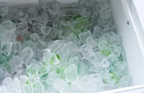 Close up on drinking cans inside ice blocks in the cooler Stock Photos