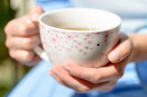 Close-up of drinking tea, no face, blurred background Stock Photos