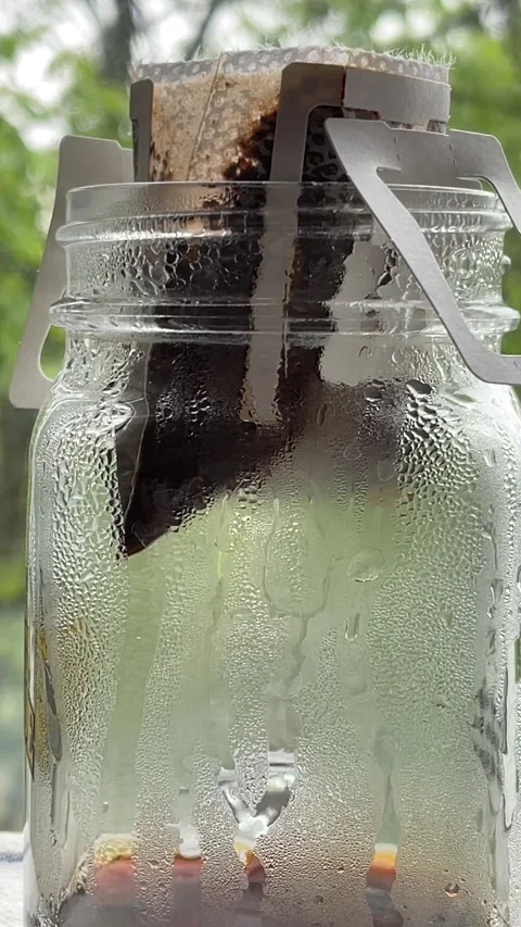 Close up of a drip coffee bag in a glass cup, pour over coffee dripping Stock Footage 272157989