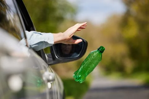 Close Up Of Driver In Car Dropping Trash Out Of Window On Country Road Stock Photos