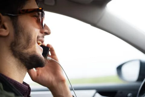 Close-up of driver face talking by smartphone. Stock Photos