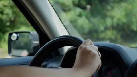 Close-up of driver hand on steering wheel, car side mirror... Stockbeeldmateriaal 316914139