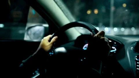 Close up of driver holding steering wheel while driving car with city street Stock-Footage 336267342