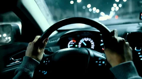 Close up of driver holding steering wheel while driving car with city street Stock-Footage 336267549