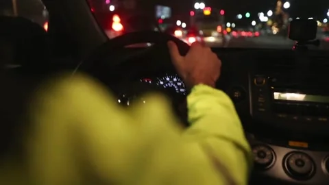 Close up of driver holding steering wheel while driving car with city street Stock-Footage 336267551