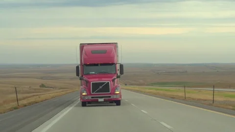 CLOSE UP Driver maneuvering big freight container semi truck driving on highway Video stock 78992251