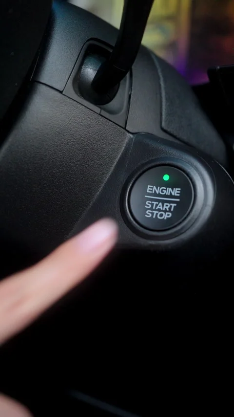 Close-up of a driver's finger about to push a car's engine start stop button Stock Footage 345330371