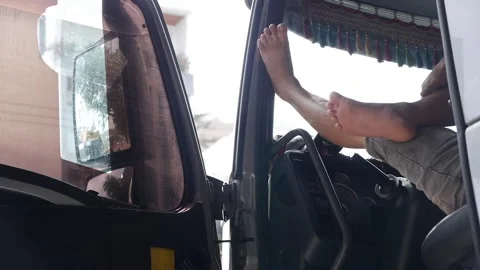 A close-up of a drivers foot resting on the dashboard of a truck. The interior Stock Footage 312783885