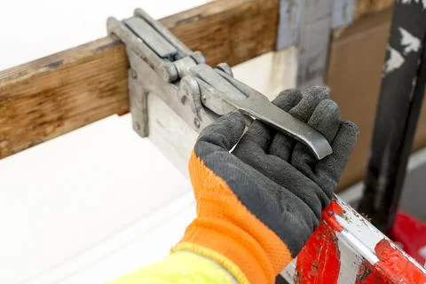 Close up of Drivers hand fastening securely a truck load using an aluminium bar. Stock Photos