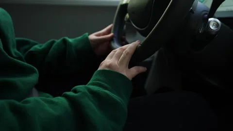Close-up of a driver’s hands on a steering wheel inside a car, with green Stock Footage 341046722