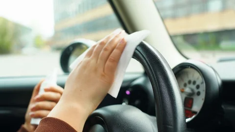 Close up of driver's hands using wipe wet with antibacterial gel for Stock Footage 129591433