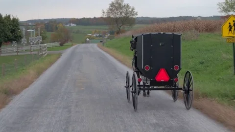 CLOSE UP: Driving behind Amish buggy past dairy farm in agricultural village Stock Footage 75846198