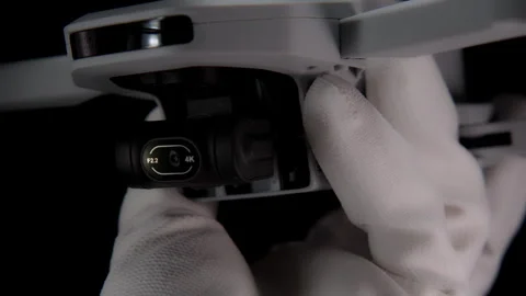 Close-Up of Drone Camera in Gloved Hand Against Black Background Stock Footage 276297683