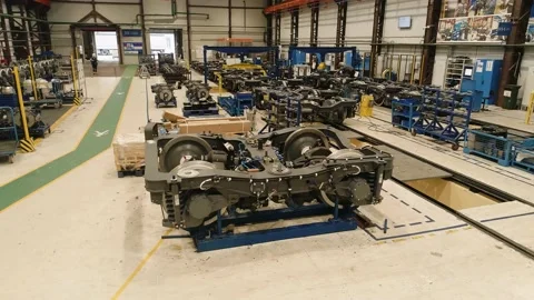 Close-up of a drone flying over a subway car chassis in an assembly shop. Work Stock Footage 195119241