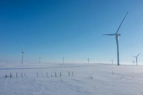 Close drone perspective of modern wind turbines standing tall across a vast Stockfoto's