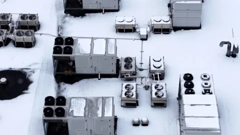 Close-up drone perspective view of HVAC system on a snowy industrial rooftop. Stock Footage 328912587